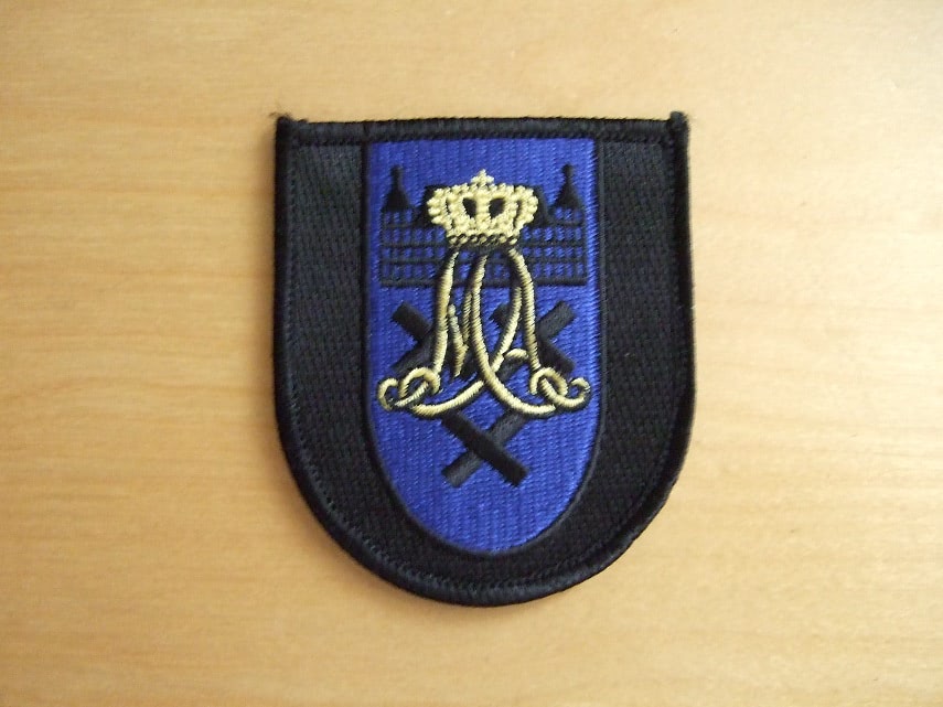 Mouwembleem Cadetteneskadron KMar KMA
Sinds 2017 heeft de Marechaussee een zelfstandig opleidingseskadron op de Koninklijke Militaire Academie (KMA) in Breda. Met het overdragen van de KMar vlag aan commandant KMA werd dat moment gemarkeerd. “Met een eigen eskadron zijn we nu een herkenbare entiteit. Dat is goed voor de onderlinge verbondenheid”, zei luitenant-generaal Harry van den Brink.
Sinds drie jaar wordt de opleiding tot officier bij de KMar gevolgd aan de KMA. Tot vandaag gebeurde dit gezamenlijk met cadetten van andere krijgsmachtdelen.
