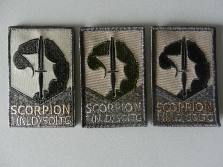 Drie verschillende Scorpionemblemen
De 1e uitvoering is het origineel wat door het KCT is ontworpen en uitgegeven.
De 2e uitvoering is een extra aanmaak in opdracht van de CSM 1e rotatie SOLTG, echter de kleur was fout (groene scorpionstaart)
De 3e uitvoering is toen in opdracht van de CSM 1e rotatie gemaakt, als vervanger van uitvoering 2 en verstrekt aan hen die een 2e embleem wilden hebben.

Met dank aan Pieter Vlam
